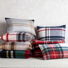 several plaid pillows stacked on top of each other