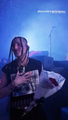 a man with dreadlocks standing in front of a stage