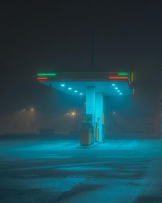 an empty gas station at night with fog