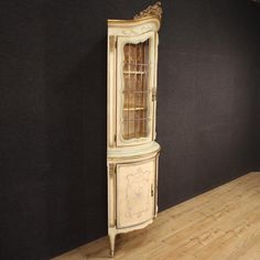 an antique corner cabinet with glass doors