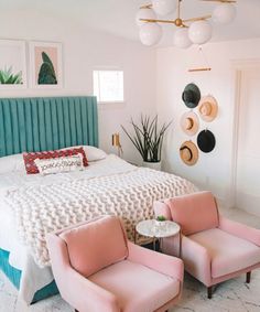 a bedroom with two chairs and a bed in the middle, one has pink upholstered bedspread