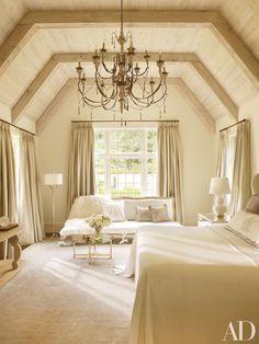 a bedroom with a chandelier hanging from the ceiling and a bed in front of a window