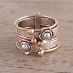 Neetu Barathi of India designs this beautiful meditation spinner ring. Two bands of sterling silver are adorned with flowers, while each of four copper and brass bands features a polished sphere. Multi Band Ring, Meditation Rings, Spinner Ring, Rings Cool, Spinner Rings, Copper And Brass, Sterling Silver Cross, Silver Pendants, Silver Cross