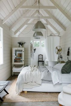 a bedroom with white walls and wooden floors, an exposed ceiling is the focal point in this photo