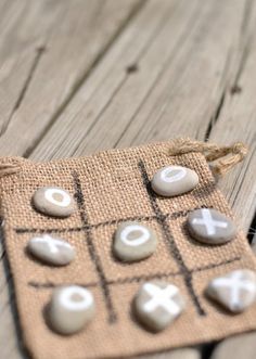 a tic - tac - toe game is displayed on a wooden table with rope