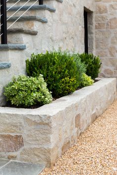 a stone planter sitting on the side of a building next to a stair case