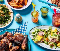 a blue table topped with plates of food and drinks