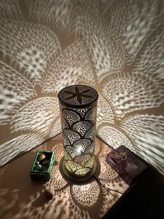 a lit candle sitting on top of a table next to a box and some books