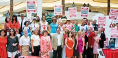 a group of people standing next to each other holding signs