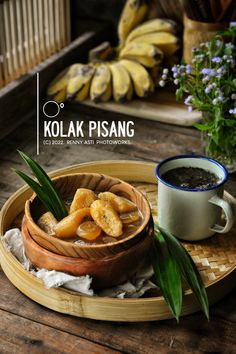 a wooden tray topped with sliced oranges next to a cup of coffee and bananas