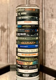 a stack of dvd's sitting on top of a glass table next to a wooden wall