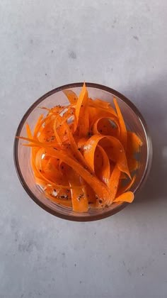 carrots are in a glass bowl on the counter top, ready to be cooked