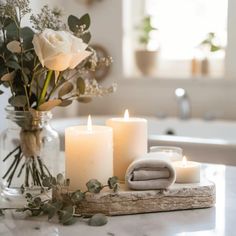 candles and towels sit on a marble counter top