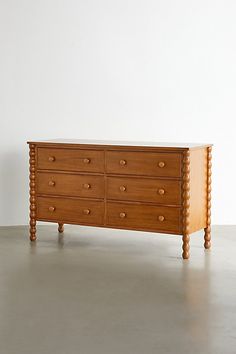 a large wooden dresser sitting on top of a cement floor next to a white wall