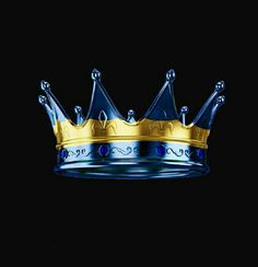 a blue and gold crown sitting on top of a black surface with water droplets around it