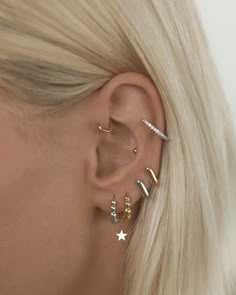 a woman with blonde hair wearing three different ear piercings