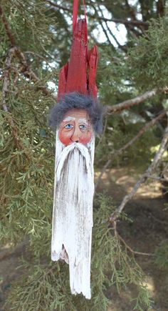 a red and white wooden ornament with a man's face on it