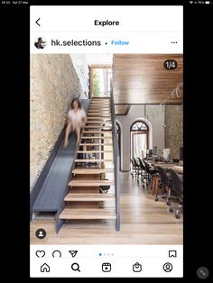 a woman is walking down the stairs in a house with stone walls and wood flooring