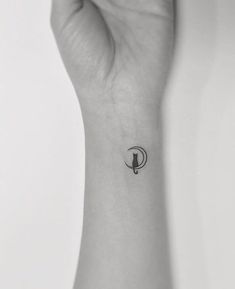 a black and white photo of a person's wrist with a small bird on it