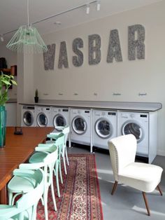 a laundry room with washers and chairs in it