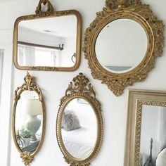 three mirrors are hanging on the wall above a bed and another mirror is next to it