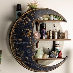 a shelf with various items on it in the shape of an moon, hanging from a wall