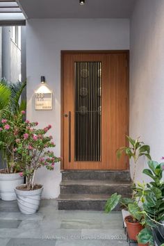 two potted plants are sitting in front of a door