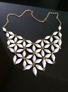 a white necklace with gold chains and seashells