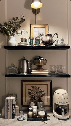 a shelf with coffee cups, tea kettles and other items on top of it