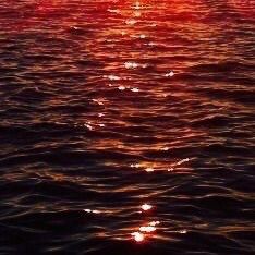 the sun is setting over the water and it looks like they are floating in the ocean