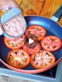 a person is cooking tomatoes in a pan on the stove