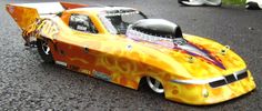 a toy car with flames painted on it's body and hood sitting in the street