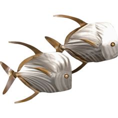 two metal fish sculptures sitting next to each other on a white surface with gold accents