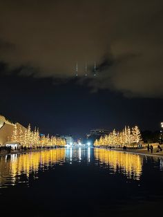 the lights are reflecting in the water at night