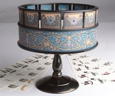 an elaborately decorated table with playing cards on it and a card holder in the middle