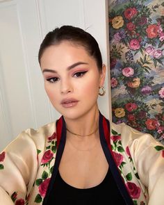 a woman in a floral jacket is taking a selfie