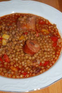 a white bowl filled with beans and sausage