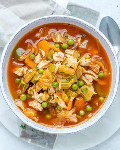 a white bowl filled with chicken and vegetable soup