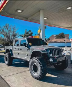 a gray jeep parked at a gas station