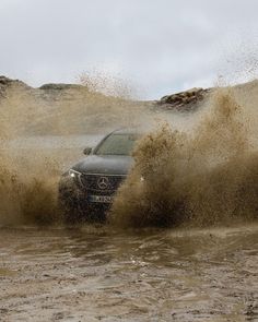 a car is driving through some water in the mud