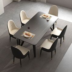 a dining room table with chairs and plates on the placemat in front of it