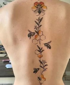 the back of a woman's body with bees and honeycombs on it