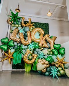 a large balloon sign that says laugh surrounded by green and gold balloons in the shape of stars