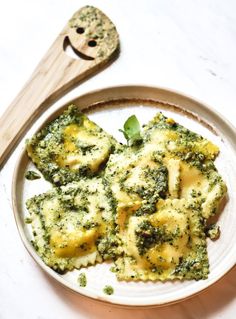 broccoli and ravioli on a plate with a wooden spoon