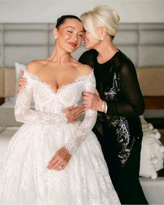 two women in wedding dresses hugging each other