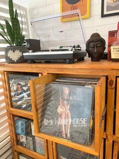 an old record player is sitting on top of a wooden entertainment center with cd's