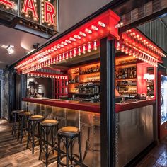 a bar with stools and neon lights