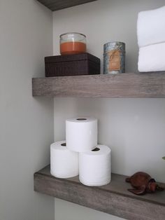 bathroom shelves with toilet paper and candles on them