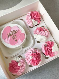 pink and white cupcakes in a box on the floor