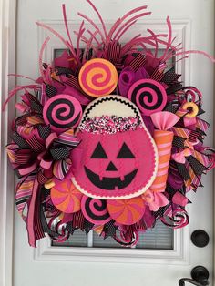 a pink and black halloween wreath with a jack - o'- lantern on it